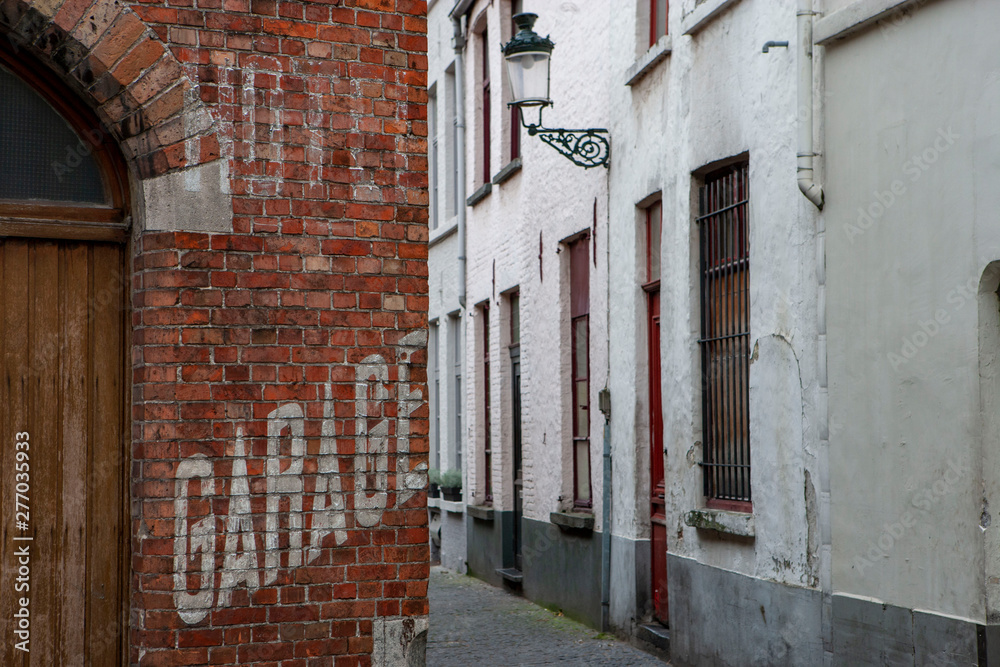 Historic city of Brugge Belgium. Brickwall with faded advertising Garage