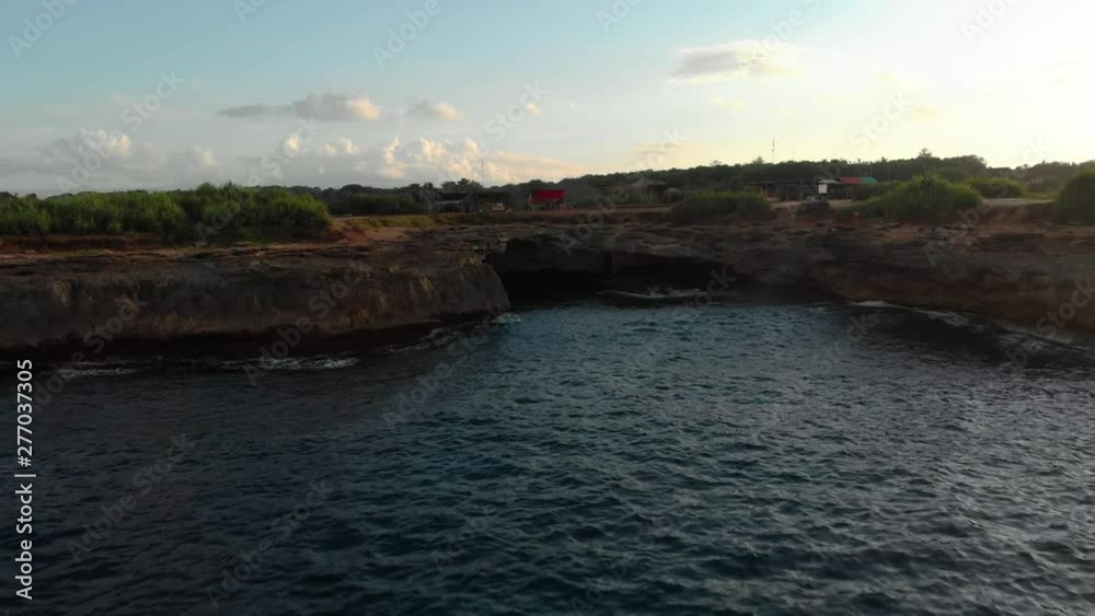 Drone flying from a cave at the shoreline , aerial shot. Drone flying from a cave at the shoreline , aerial shot.