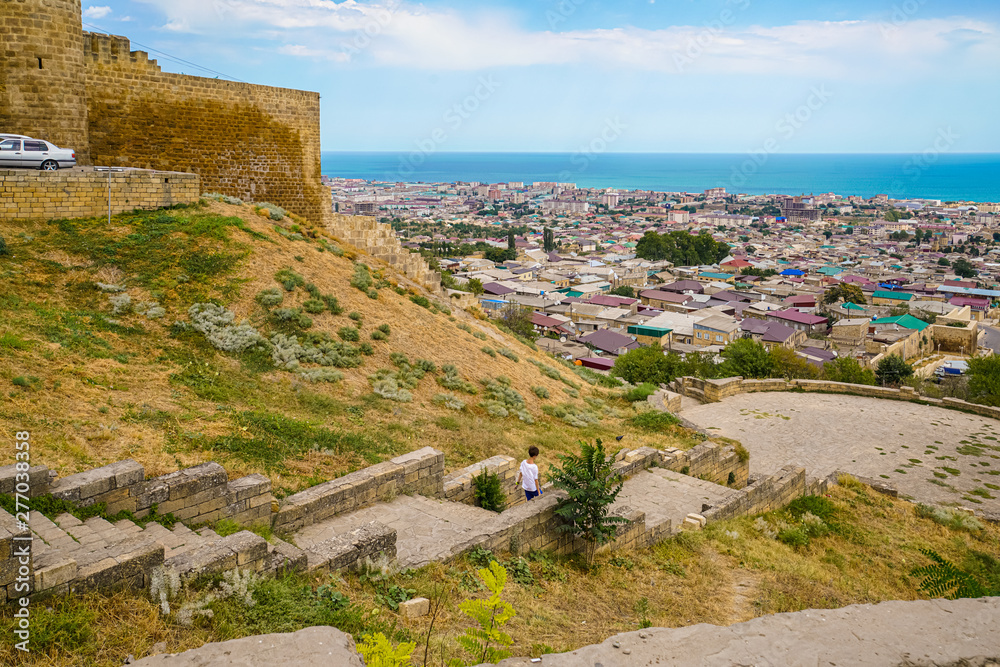 View of the city of Derbent and the Caspian Sea from the Naryn-Kala fortress. A staircase leads from the entrance to the fortress to the observation deck, located slightly below. View of the city of Derbent and the Caspian Sea from the Naryn-Kala fortress. A staircase leads from the entrance to the fortress to the observation deck, located slightly below.