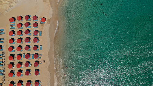 Aerial drone photo of famous organised with sun beds and umbrellas beach of Lia with emerald clear sandy sea shore, Mykonos island, Cyclades, Greece 
