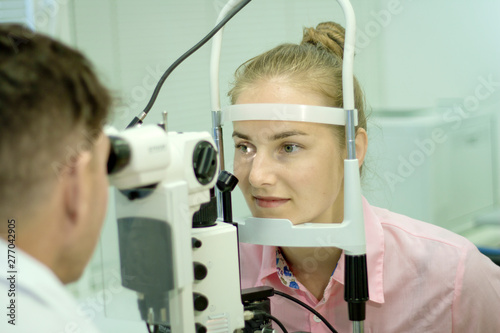 A young woman undergoes an ophthalmological examination  checking the health of the eyes and visual acuity.