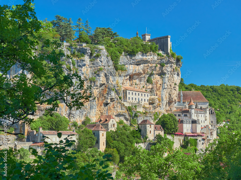 Landscape view through the forest of the medieval french village of Rocamadour, on a cliff of the alzou river valley, Lot Department, Quercy, Occitanie Region, France. UNESCO world heritage site.