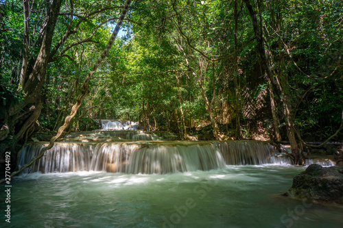 The clean waterfall there is an emerald green colour caused by reflections from trees and lichen circulating through the yellow limestone. Huai Mae Khamin Waterfall, Kanchanaburi Province
