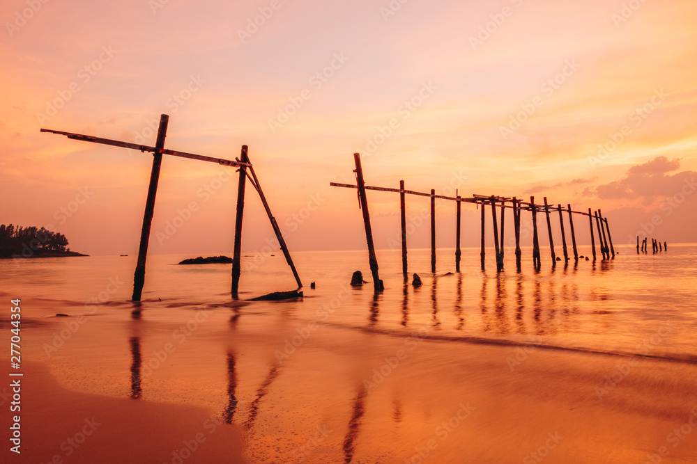 The old wooden bridge and sea wave on the beach at sunset sky background at Khao Pilai, Phangnga, Thailand. Nature landscape