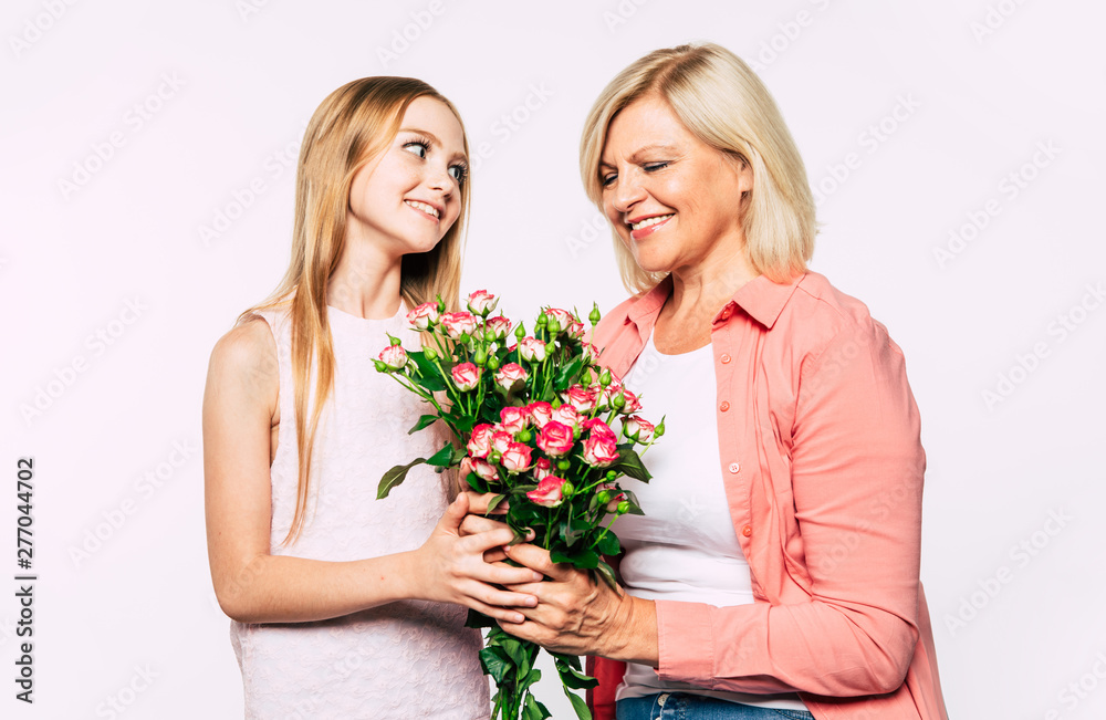 Surprise! I love my grandma. Family holidays and celebrations. Close up photo of happy grandmother and granddaughter in good and fun mood isolated together on white background. Surprise! I love my grandma. Family holidays and celebrations. Close up photo of happy grandmother and granddaughter in good and fun mood isolated together on white background.
