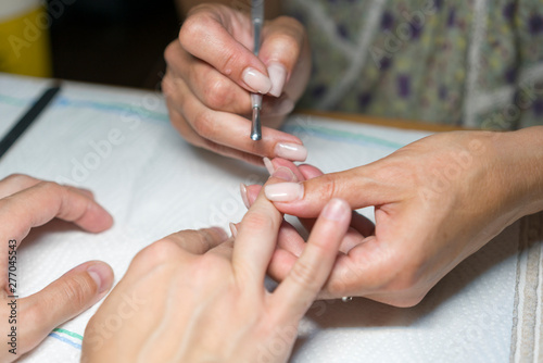 Close up woman hand while process of manicure in nail shop. Beautiful concept. female nail manicure processing