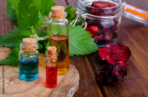 Glass bottles of aroma essential oil on wooden background  image for alternative therapy medicine