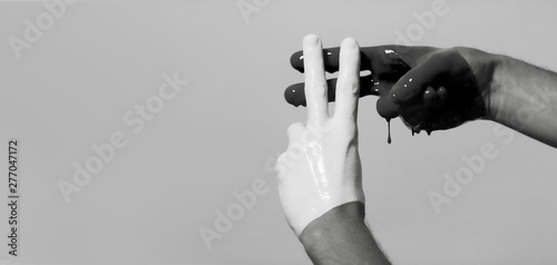 black and white male hands in paint crossed in a hashtag sign on a studio background, creative advertising, social networks concept