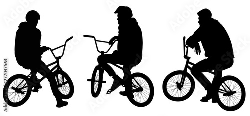 Silhouettes of tree teenagers sitting on bicycles