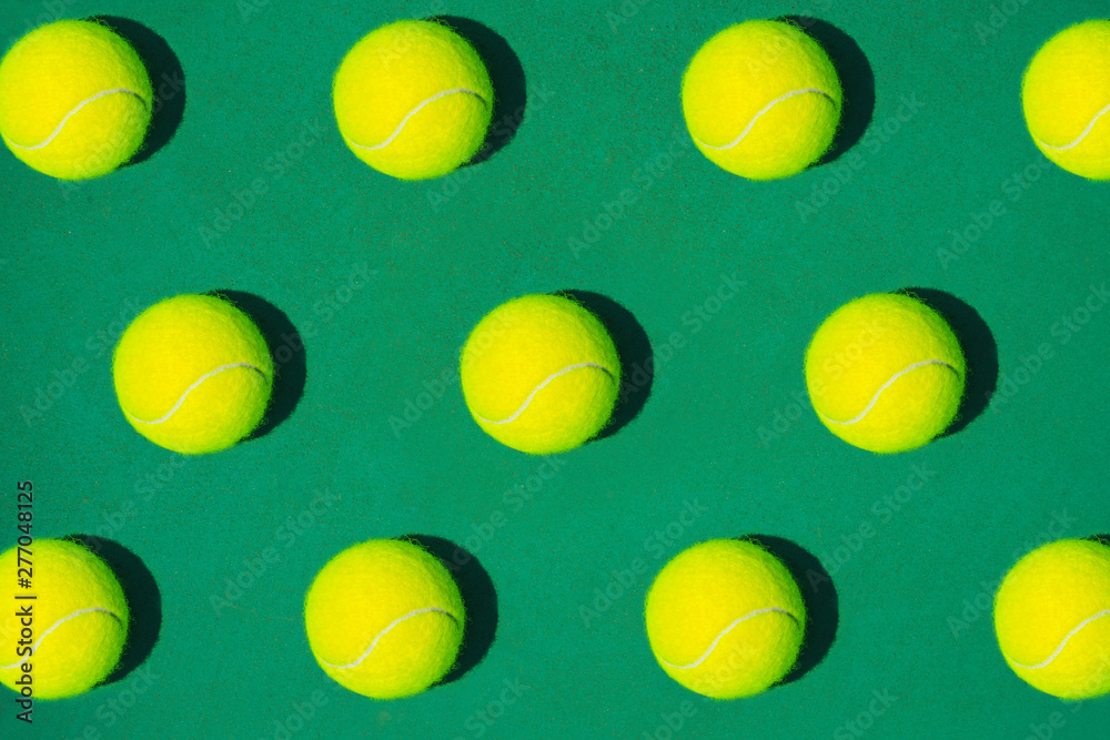 Creative composition made with tennis ball on green background. Sport tennis pattern. Flat lay.
