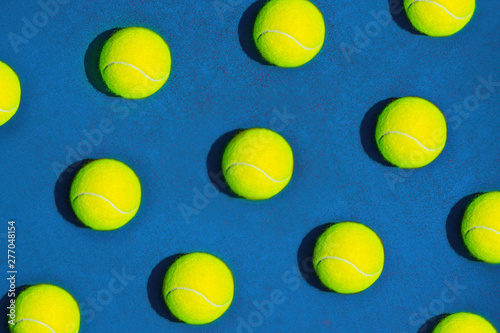 Creative composition made with tennis ball on blue background. Sport tennis pattern. Flat lay.