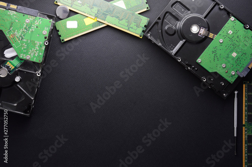 Isolated hard drives, RAM and a set of screwdrivers for computer repair on a black matte background. The concept of data storage and PC repair