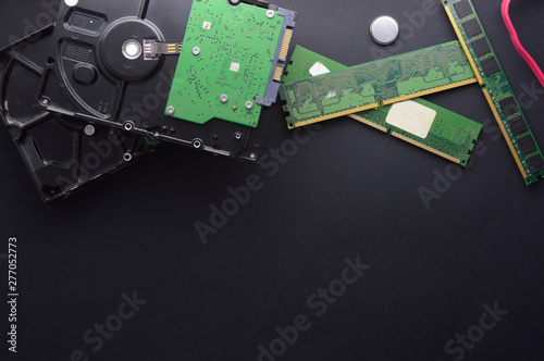 Isolated hard drives, RAM and a set of screwdrivers for computer repair on a black matte background. The concept of data storage and PC repair