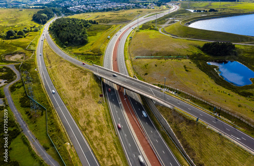 Aerial drone view of a large, new dual carriageway road with motion blurred vehicles (A465, Wales, UK)