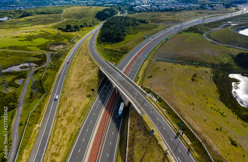 Aerial drone view of a large, new dual carriageway road with motion blurred vehicles (A465, Wales, UK)