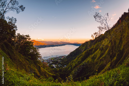 Batur volcano and lake with trees in Bali. Sunrise time in mountains