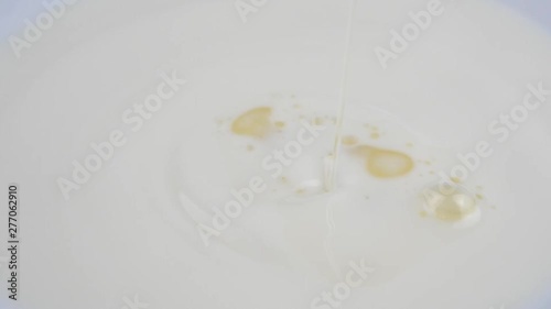Pouring oil into milk. Slow Motion. photo