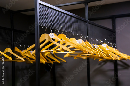 Obraz na plátně bright wooden hangers with numbers in empty cloakroom or checkroom or wardrobe