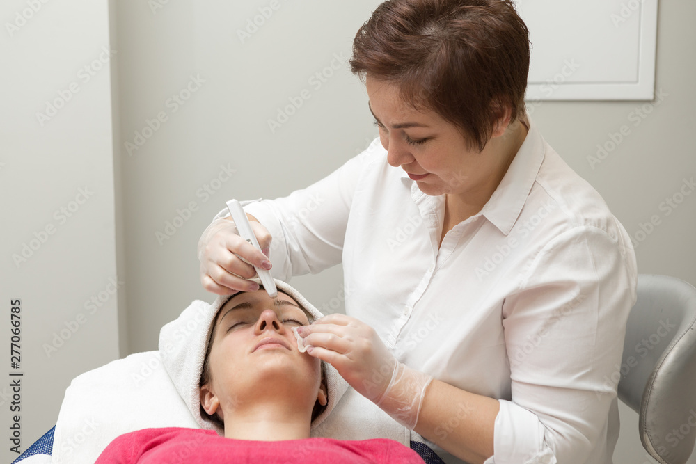 Face skin care. Beautician applying beauty oil mask on face using brush In spa salon Face skin care. Beautician applying beauty oil mask on face using brush In spa salon