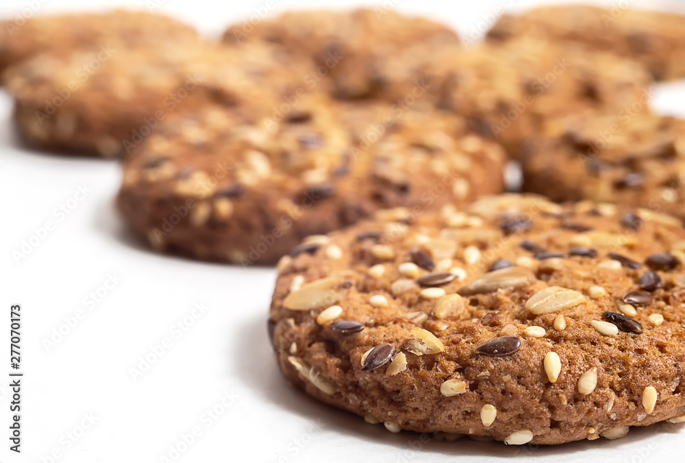 Macro photo of brown dietary low-calorie fitness cereal biscuits with sprinkling closeup on white background.