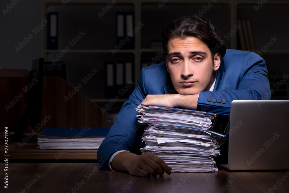 Fototapeta premium Young male employee working night in the office 