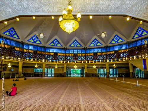 Photography KUALA LUMPUR, MALAYSIA - DECEMBER 31, 2014: Unidentified people praying in the National Mosque of Malaysia (Masjid Negara)