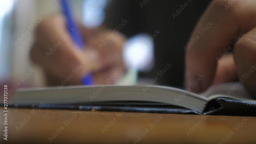 man writes in notebook. man's hand writing in a notepad. concept business education. man makes notes in notebook lifestyle that lies on the table