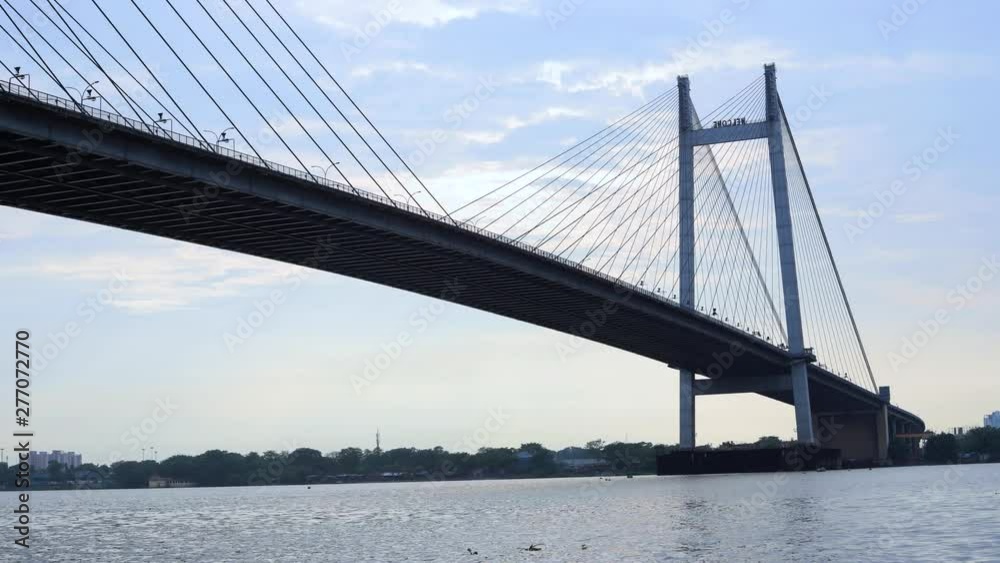 4K Timelapse of a beautiful clouds over Kolkata city with a view of Vidyasagar Bridge on the Ganga river, West Bengal, India.