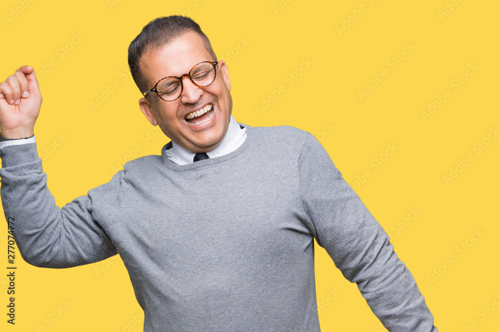 Middle age bussines arab man wearing glasses over isolated background Dancing happy and cheerful, smiling moving casual and confident listening to music Middle age bussines arab man wearing glasses over isolated background Dancing happy and cheerful, smiling moving casual and confident listening to music