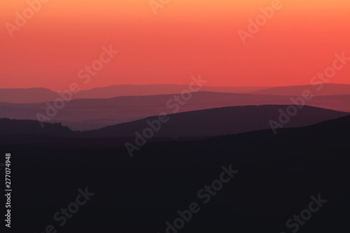 Mountain layer silhouettes after sunset with orange color tones. Harz National Park in Germany © Ricardo