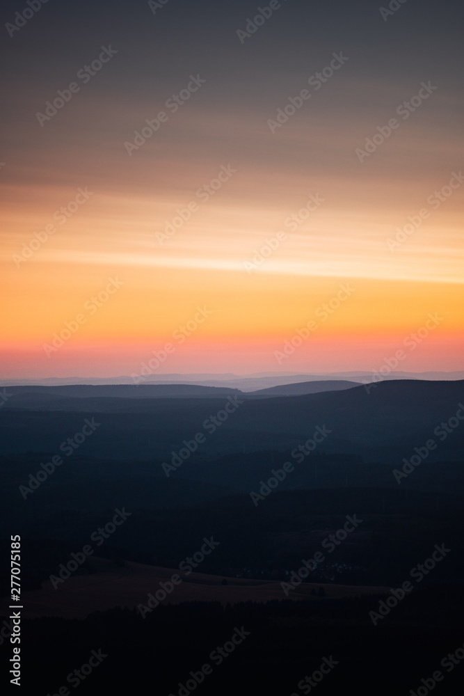 Mountain panorama view with mountain silhouettes an sunset color tones. Harz National Park, Wolfswarte