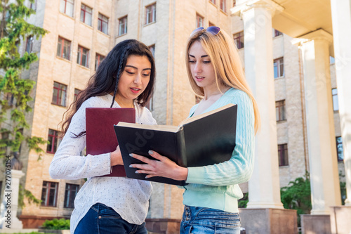 two female students study textbook