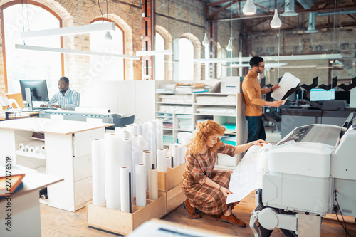 Red-haired interior designer printing sketches for project