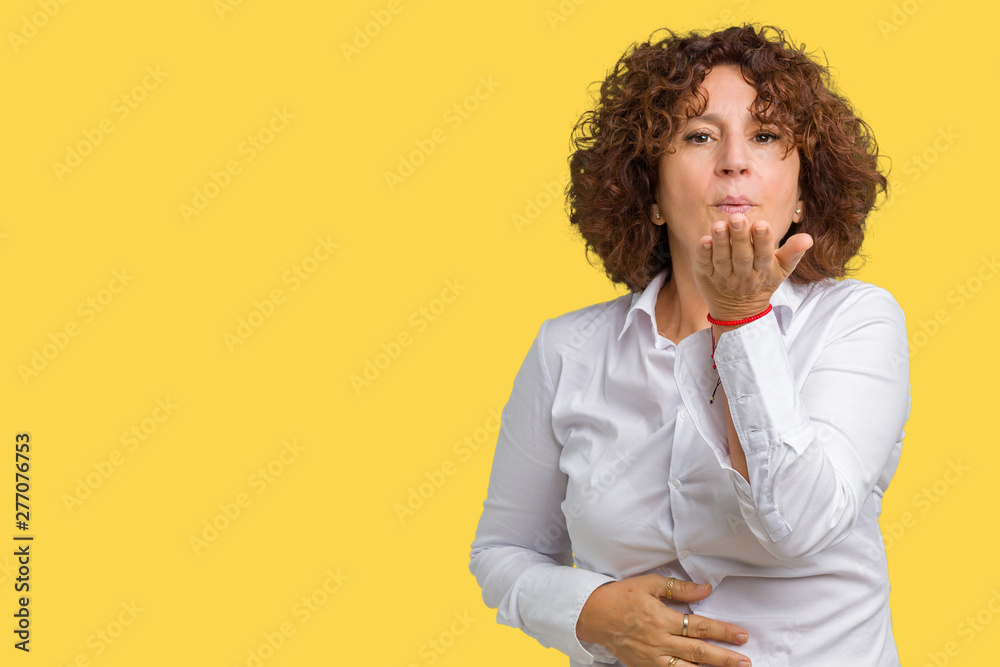 Beautiful middle ager senior businees woman over isolated background looking at the camera blowing a kiss with hand on air being lovely and sexy. Love expression. Beautiful middle ager senior businees woman over isolated background looking at the camera blowing a kiss with hand on air being lovely and sexy. Love expression.
