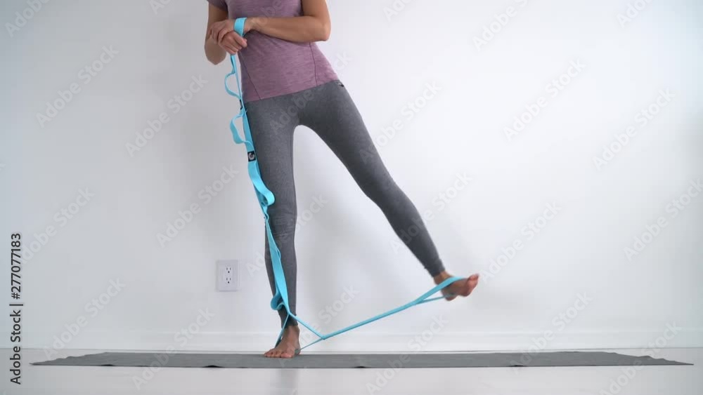 Resistance band fitness girl doing standing side lateral leg raise for