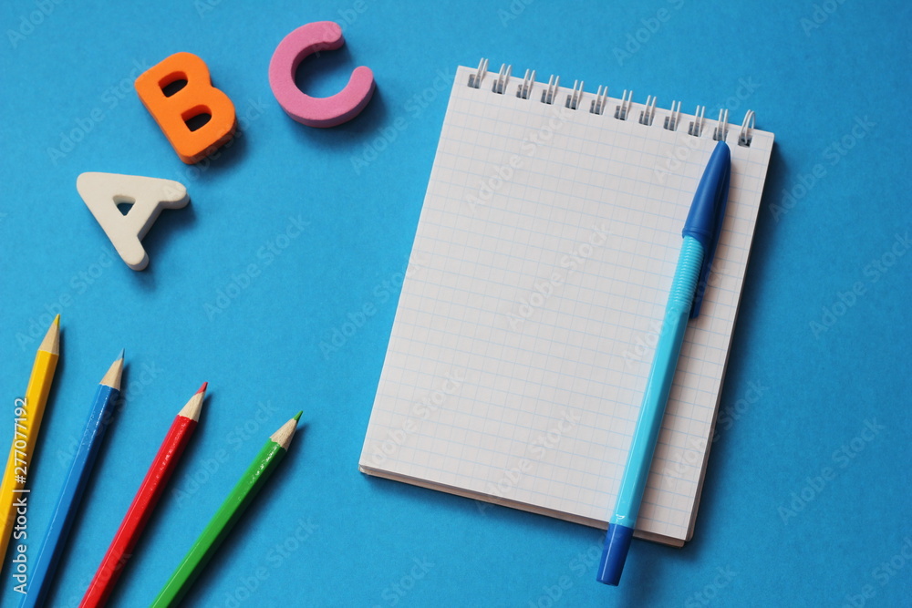 ABC-the first letters of the English alphabet on a blue background. Notebook and pen. Empty space for text. Learn foreign languages. ABC-the first letters of the English alphabet on a blue background. Notebook and pen. Empty space for text. Learn foreign languages.