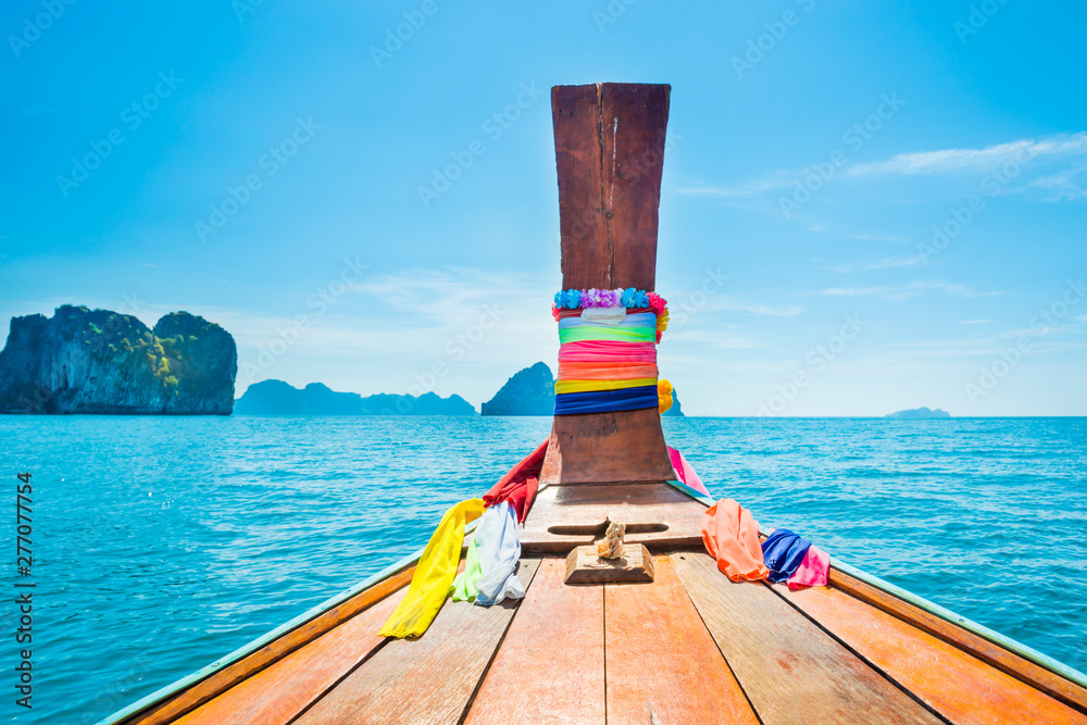 View from head of traditional wooden boat to blue sea and tropical islands