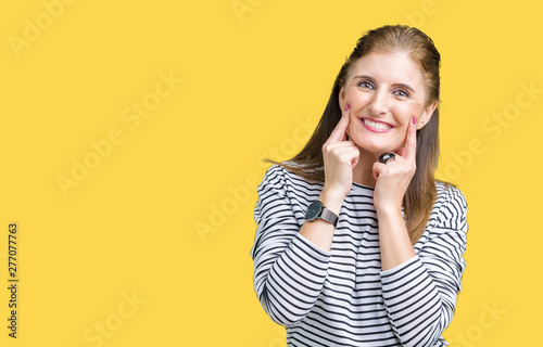Middle age mature beautiful woman wearing stripes winter sweater over isolated background Smiling with open mouth, fingers pointing and forcing cheerful smile