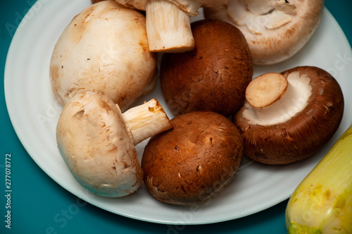 brown and white mushrooms and zucchini on the blue background