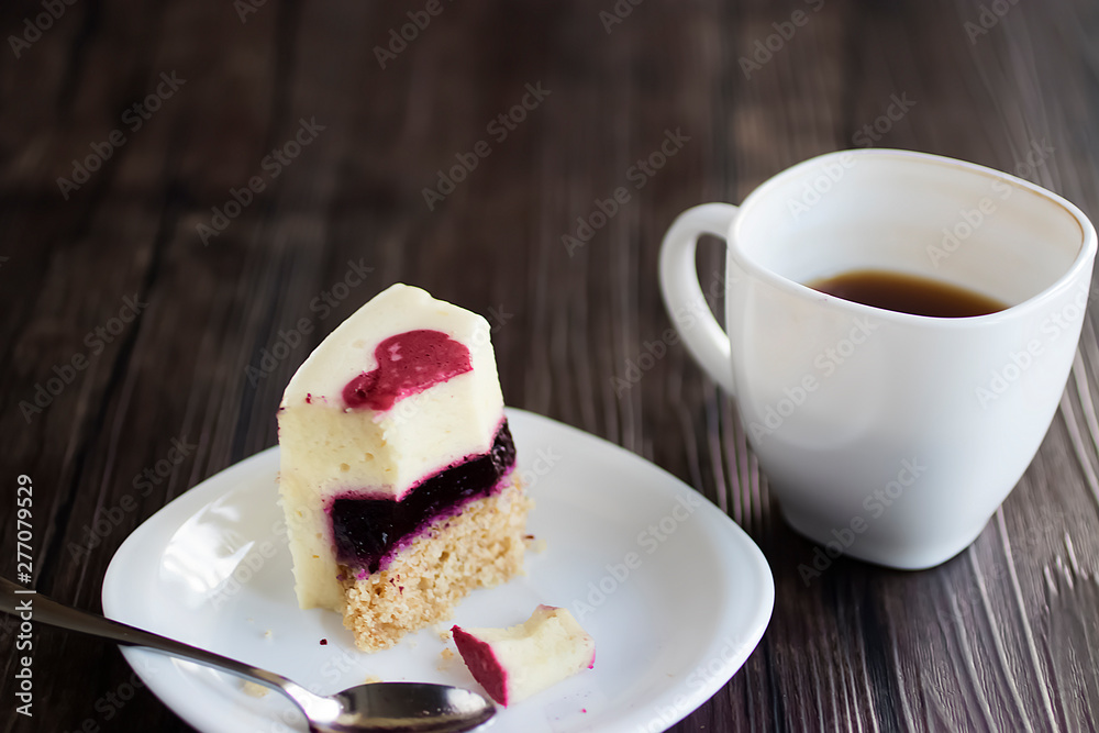Gluten-free and sugar-free vegan cake on a white plate and white sashka coffee on a brown wooden table.