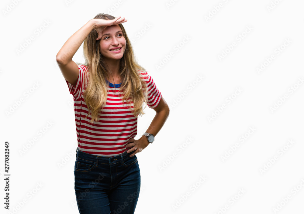 Young beautiful blonde woman over isolated background very happy and smiling looking far away with hand over head. Searching concept. Young beautiful blonde woman over isolated background very happy and smiling looking far away with hand over head. Searching concept.