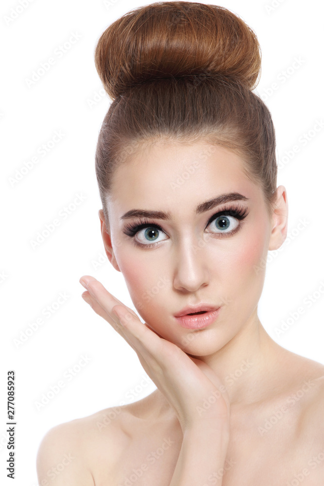 Portrait of young beautiful girl with fancy hair bun and shocked expression