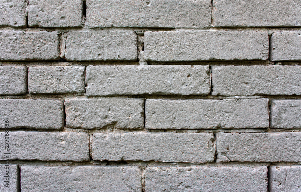 Obraz premium An old, damaged wall of gray bricks - a wabi-sabi style background