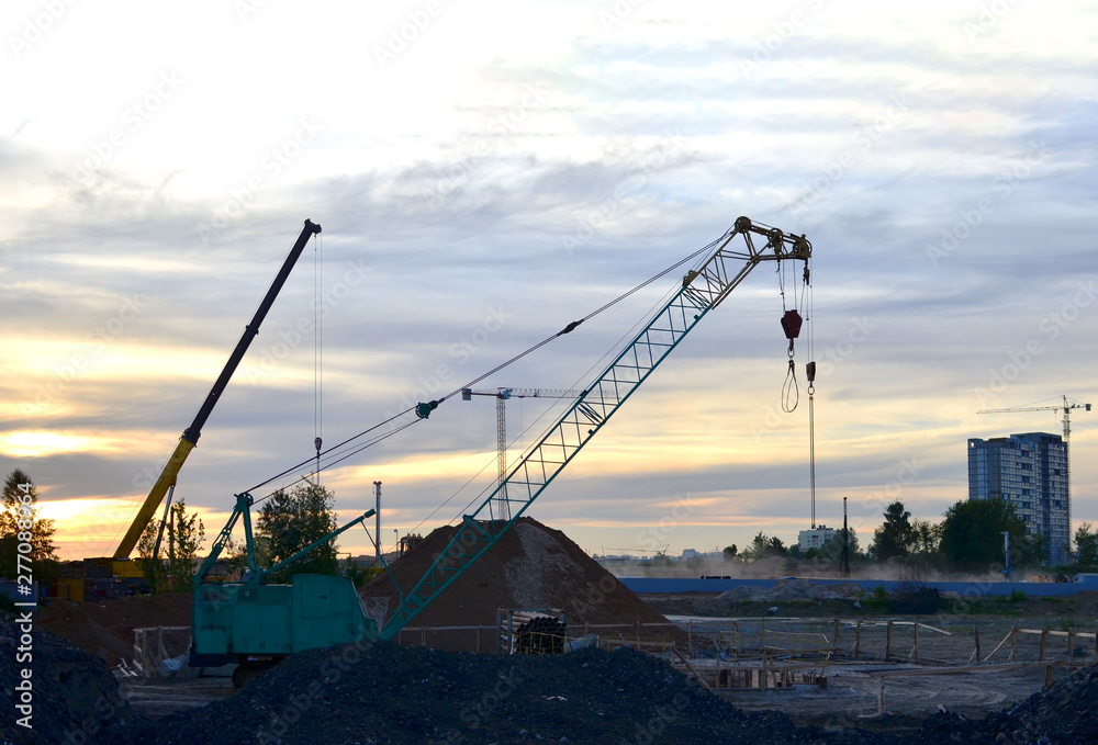 Crawler crane on the construction site for loading and unloading and construction works for laying sewer pipes and communications in the pit - Image
