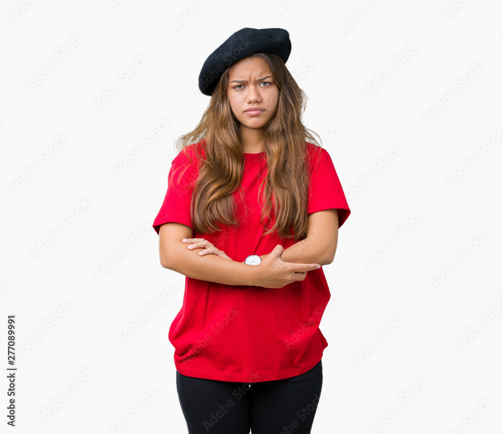Young beautiful brunette fashion woman wearing red t-shirt and black beret over isolated background skeptic and nervous, disapproving expression on face with crossed arms. Negative person. Young beautiful brunette fashion woman wearing red t-shirt and black beret over isolated background skeptic and nervous, disapproving expression on face with crossed arms. Negative person.