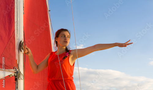 woman on the sailboat points forward photo