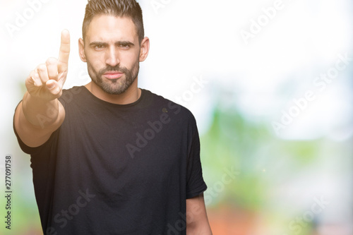 Young handsome man over isolated background Pointing with finger up and angry expression