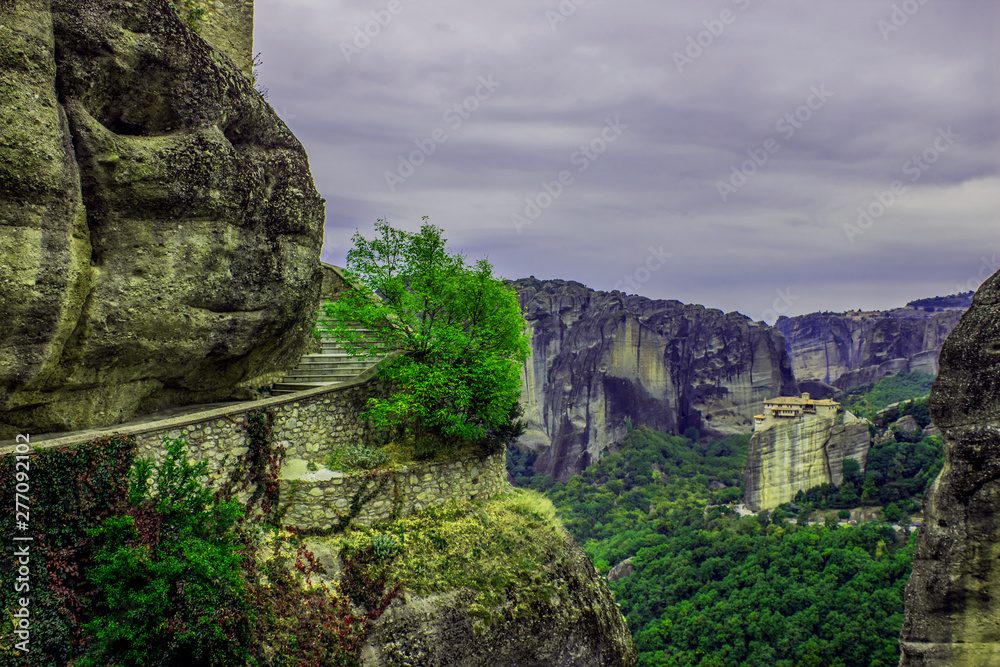upstairs pilgrimage path way christian holy road around rock in Greece European world heritage site dramatic scenery landscape and mountains background in cloudy weather time 