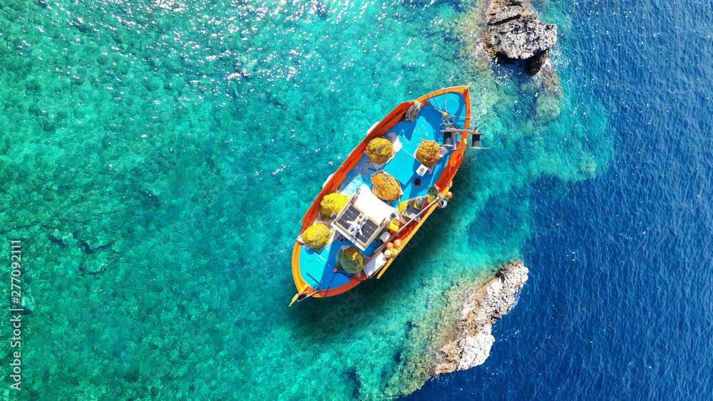 Aerial drone top view photo of red wooden traditional fishing boat in deep turquoise sea shore of Lefkada island, Ionian, Greece - obrazy, fototapety, plakaty 
