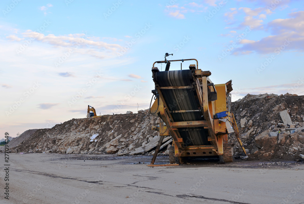 Mobile Stone crusher machine by the construction site or mining quarry for crushing old concrete slabs into gravel and subsequent cement production